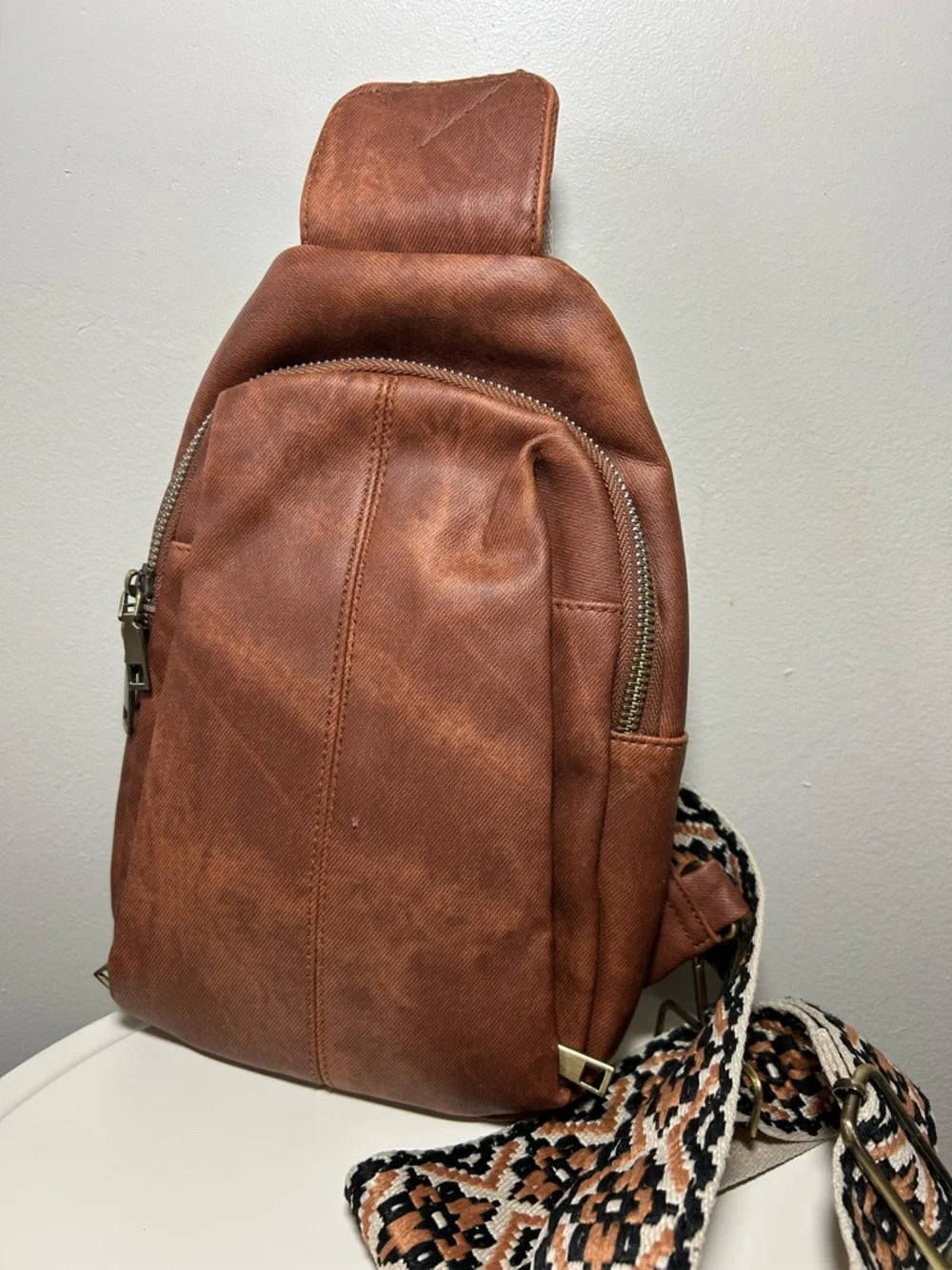 Brown Faux Leather Sling Backpack with Patterned Strap